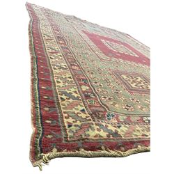 Turkish deep pink and green ground carpet, the square field with hooked borders surrounded by geometric motifs, multi-band border with overall geometric designs 