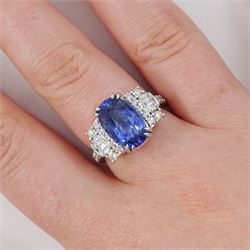 18ct white gold Ceylon sapphire and diamond dress ring, single oval cut sapphire of 4.65 carat, either side set with round brilliant cut and baguette cut diamonds and diamond set shoulders, stamped 750, total diamond weight 0.77 carat, with World Gemological Institute report