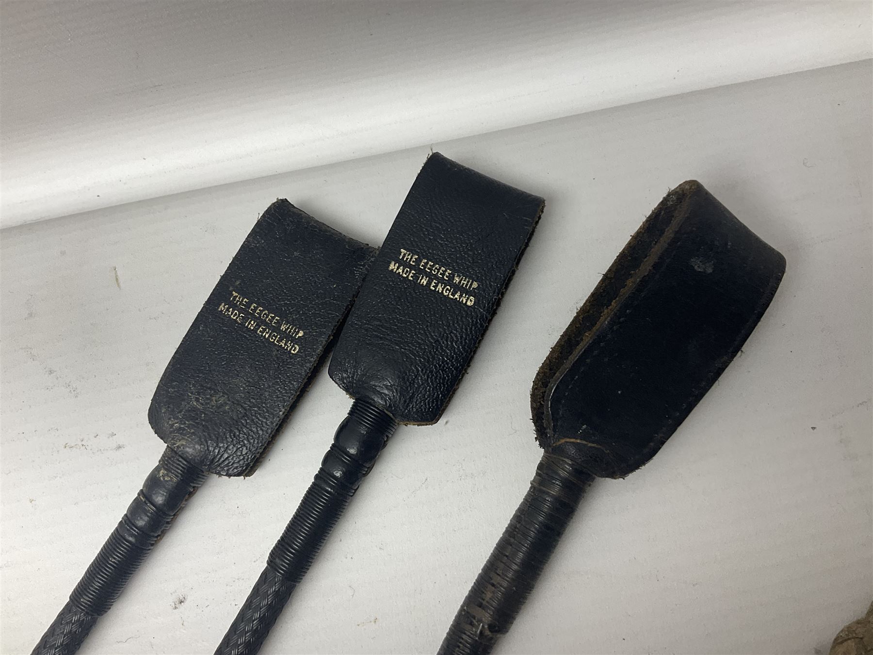 Collection of hunting crops and riding whips, including horn handle examples with silver cuffs