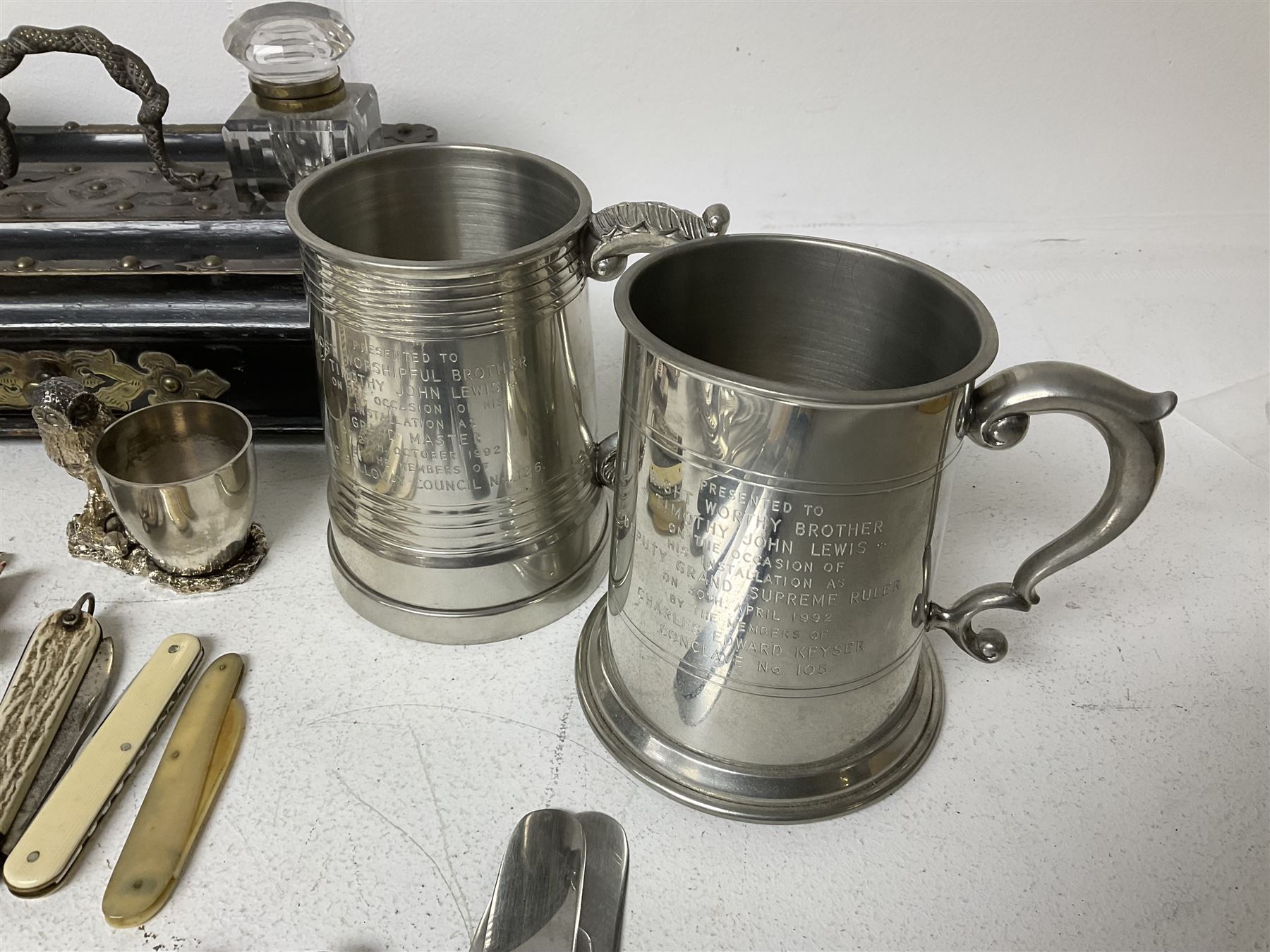 Victorian ebonised wooden desk stand, with brass mounts and two glass inkwells, together with two pewter tankards with Masonic engravings, two pewter quaiches, horn handled carving set, the fork with silver mounts and a collection of other metalware