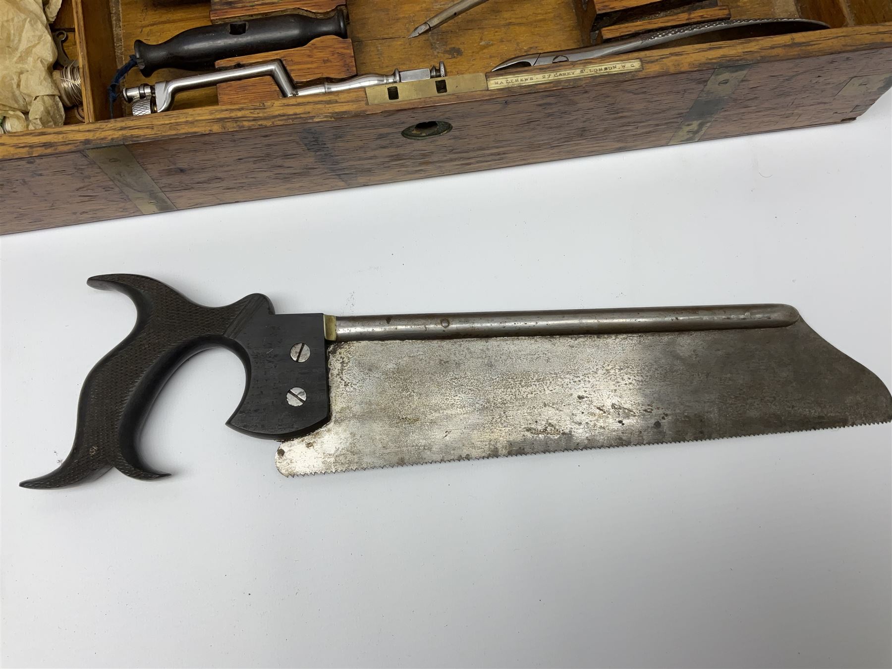 Naval doctor's surgical instruments, contained in a converted brass bound oak pistol box, the hinged lid opening to reveal two removable fitted trays, containing 19th century and later saws, scalpels, tweezers etc