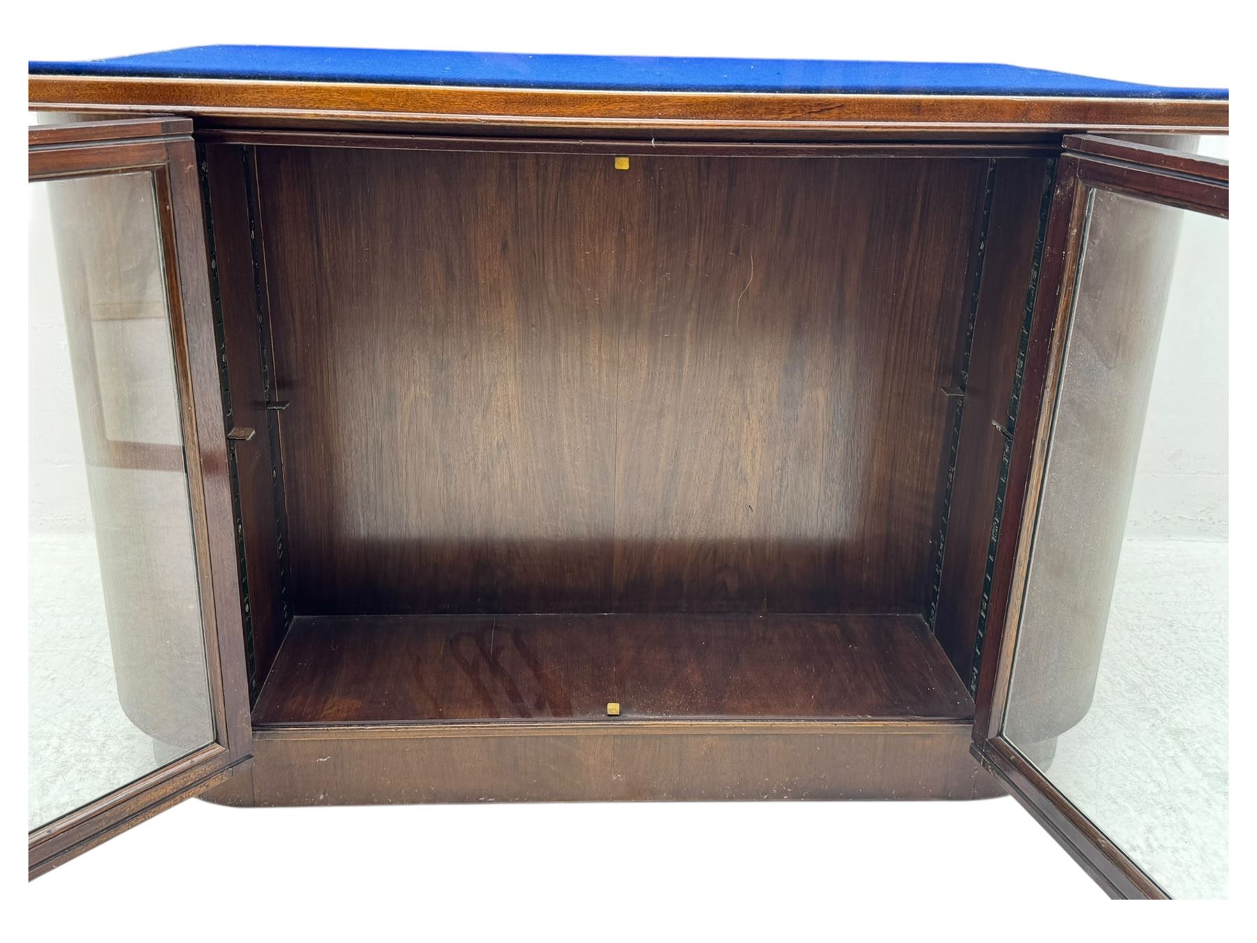 Edwardian inlaid mahogany display cabinet fitted with two glazed cupboards, fitted with rectangular glazed top and sides over a blue velvet interior, twin glazed doors below enclosing a shelved interior on a curved plinth