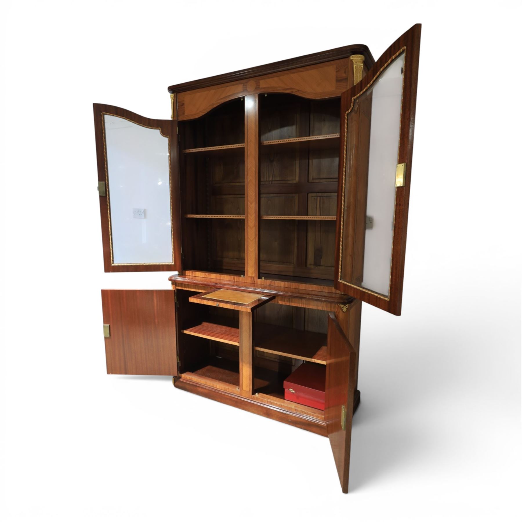 French style marquetry display bookcase, with twin glazed upper doors enclosing shelves, over a cupboard base inlaid with musical instruments and foliate decoration, the interior fitted with mirrored cupboard doors and a pull-out shelf, with gilt metal mounts and banding
