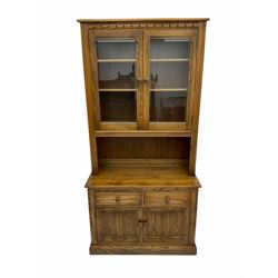 Ercol elm two door display dresser, fitted with two glazed doors above two drawers and cupboards