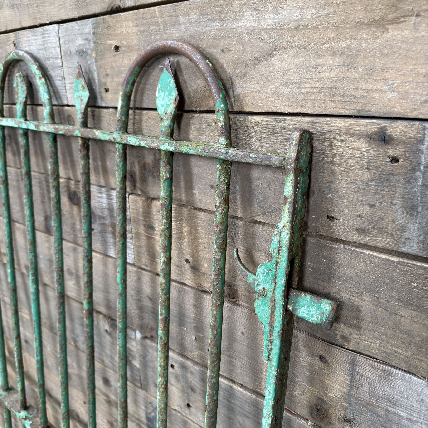 19th century French cast iron garden gate, finished in green rustic paint, bar form with hoop and spear top, with loop hinge brackets
