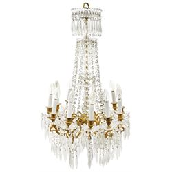 Late 20th century gilt metal and glass chandelier, with twelve gilt scroll branches strung with and supporting glass drops and swags, H96cm W56cm 
