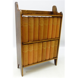  Collection of sixteen volumes of Dickens works, upholstered in red cloth, in oak bookcase, H56cm, W36cm x D14cm  