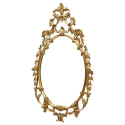 Rococo design giltwood and gesso wall mirror, oval plate within moulded frame, pierced cre...