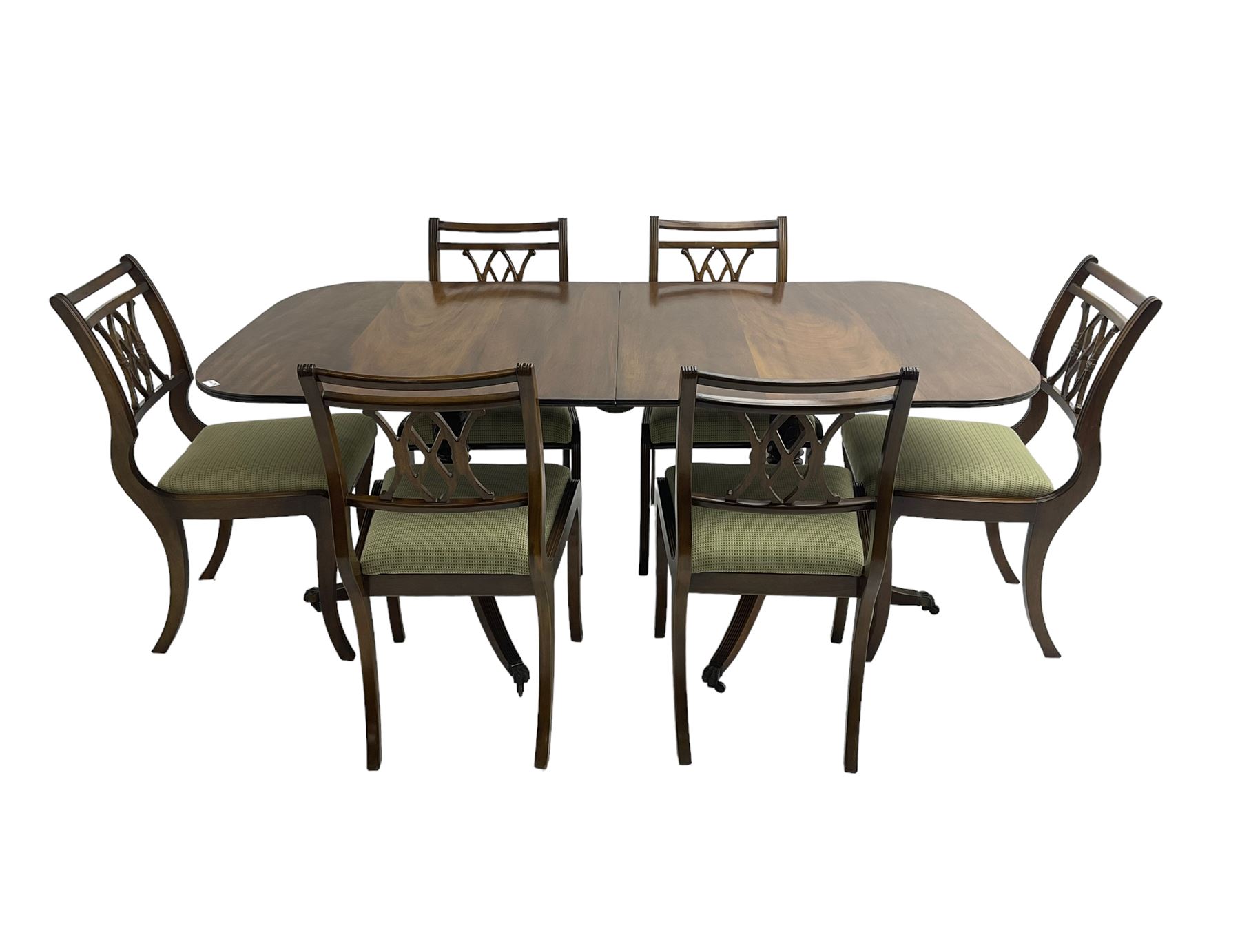 Regency design mahogany twin pedestal dining table, rectangular top with reeded edge, acanthus carved turned column terminating in reeded tripod base with hairy paw feet and castors (W172cm D92cm H75cm) and set eight (6+2) Regency design mahogany dining chairs, pierced back with scroll design, seat upholstered in patterned laurel green fabric, raised on reeded sabre supports (W48cm H88cm)