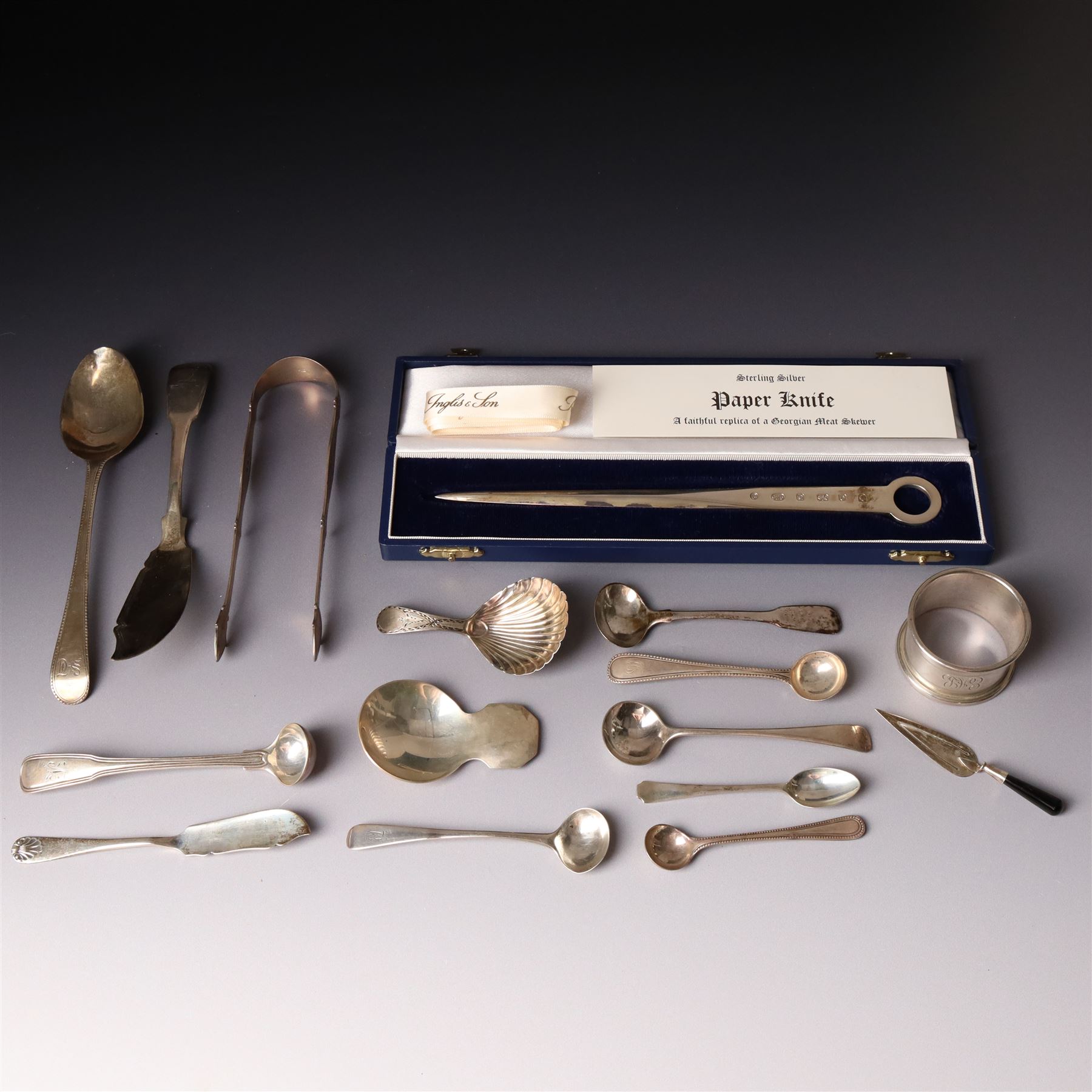 Early 19th century silver caddy spoon, Elizabeth II caddy spoon, various silver condiment spoons, sugar tongs, napkin ring, other silver cutlery and a silver paper knife, boxed