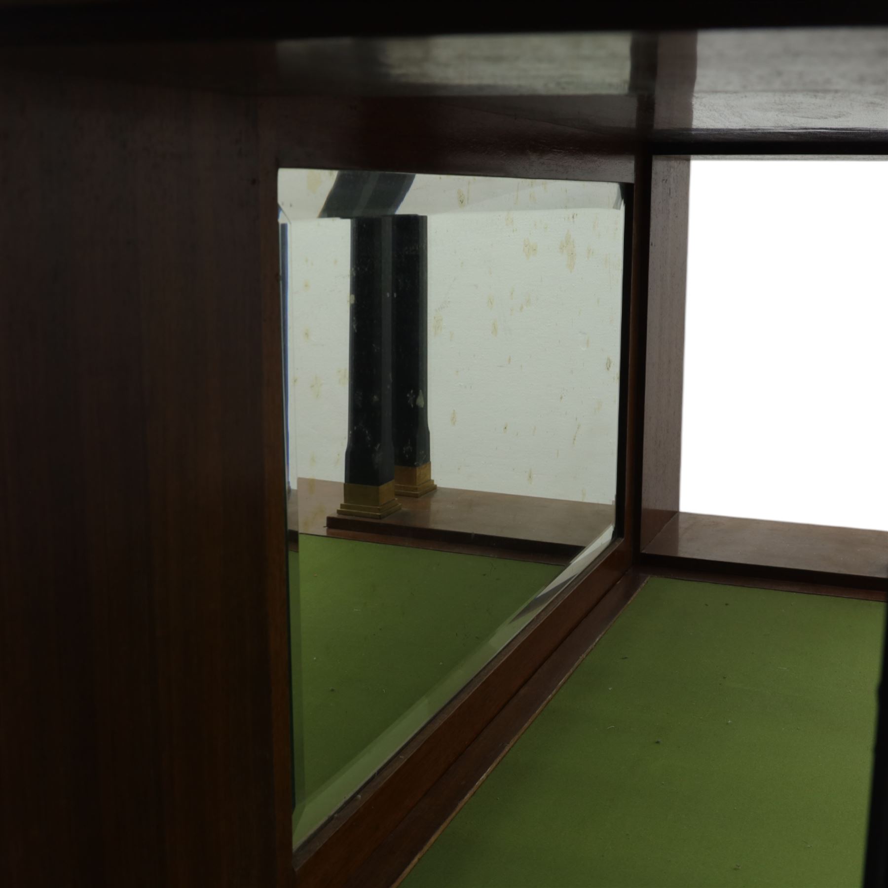 Continental Art Nouveau cocktail cabinet, the stepped cornice over a glazed upper section with panelled doors, enclosing fitted shelf, the central section with mirrored back and green baize serving surface flanked by ebonised and gilt detailed pilasters, the base fitted with cupboard doors inlaid with stylised foliate and geometric motifs, on a plinth base