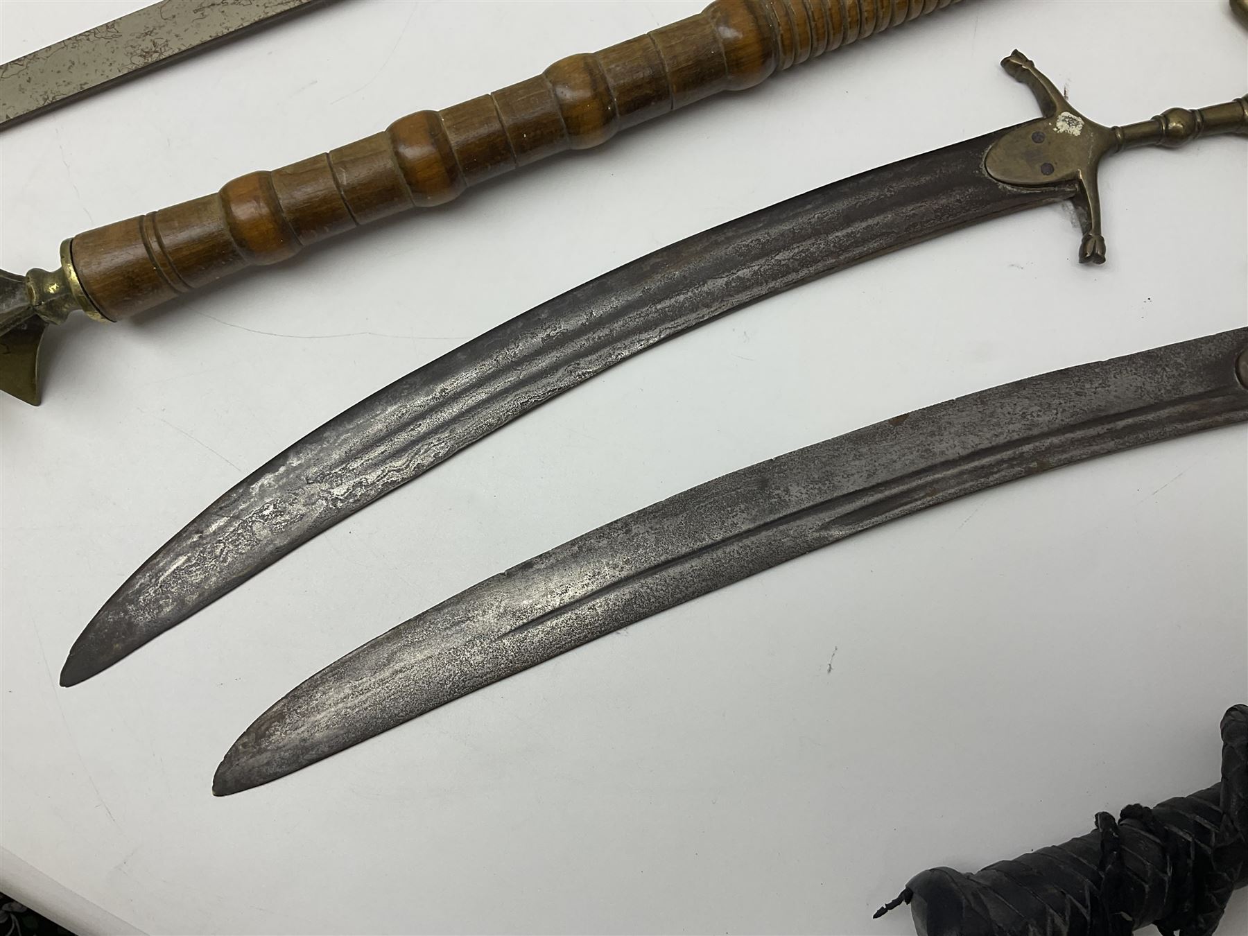 Near pair of short swords each with slightly curving 41cm fullered steel blade and all brass H-shaped hilt L52cm overall; plaited black leather whip; and reproduction pair of brass hilted swords, brass halberd blade and mace (7)