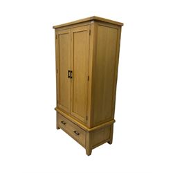 Light oak double wardrobe, enclosed by two panelled doors, fitted with single drawer