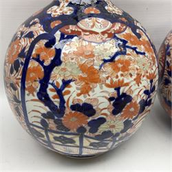 Pair of large 19th century Japanese Imari porcelain bottle vases, painted with shaped reserves of peonies, chrysanthemums and prunus blossom, each H46cm