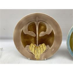 Set of three early 20th century Mintons Seccessionist plates by Leon Solon and John Wadsworth, decorated with stylised Art Nouveau tubelined patterns, comprising a pair decorated in the 'Hydrangea' pattern no. E3279, circa 1902, one with date code for 1906, together with further example moulded with a typical stylised motif tones of pink, brown and ochre with date code for 1903 all with impressed Minton and date code marks beneath, D22.5cm