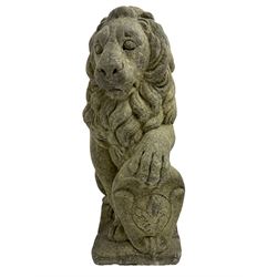 Pair of cast stone garden seated lions on plinth holding cartouche shields, looking left and right