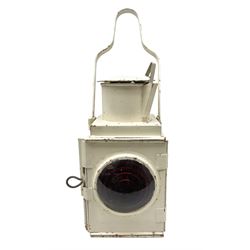 White painted railway lamp, the hinged door with red bullseye glass lens, with tall swing carrying handle, H52cm incl handle