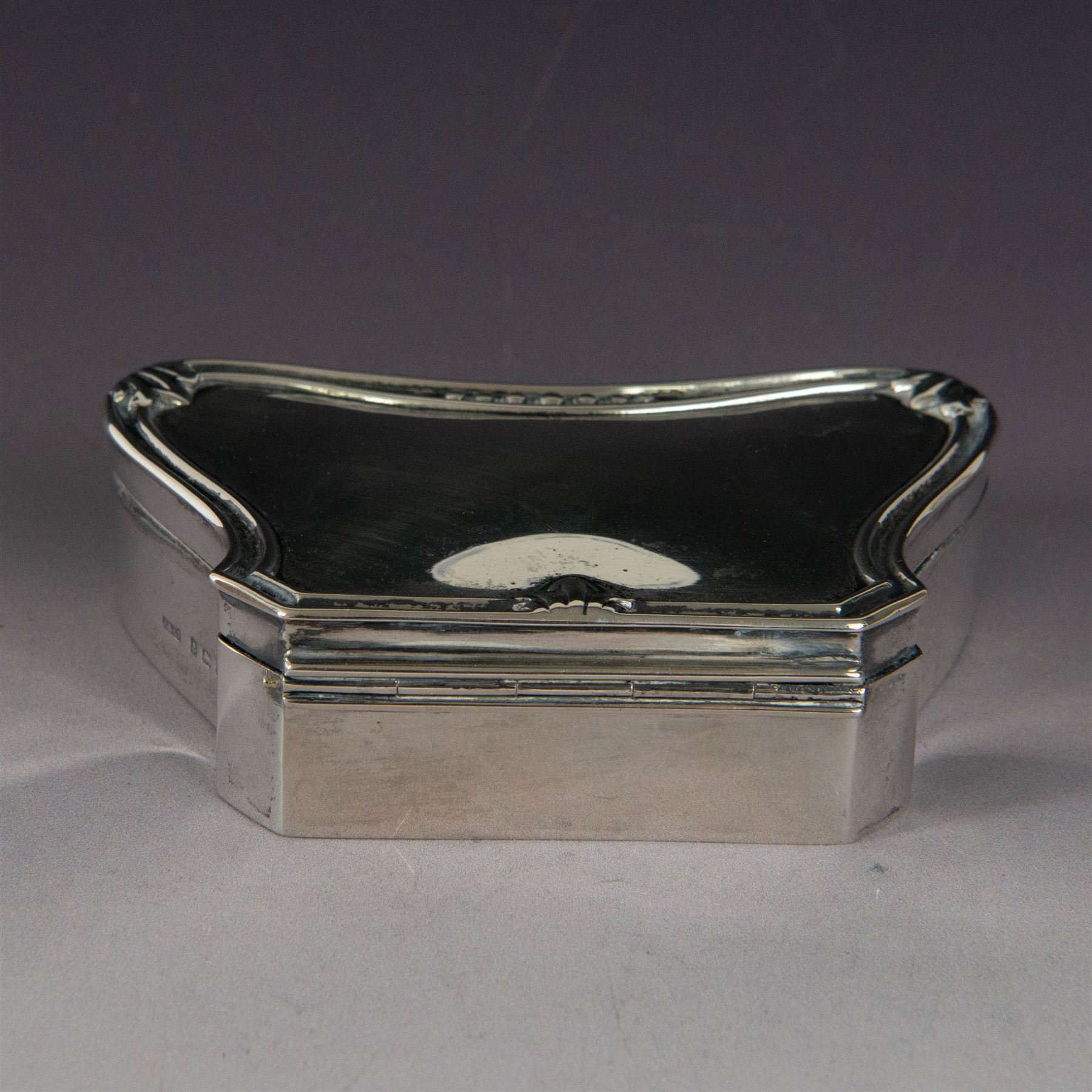 Early 20th century silver mounted jewellery box, with curved front and embossed palmette rim, opening to revel padded interior with weighted base, hallmarked A & J Zimmerman Ltd, Birmingham 1911, H3cm, W11cm