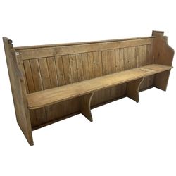 Early 20th century pine church pew, vertical plank back over rectangular seat, flanked by shaped end supports, with bible rest to back