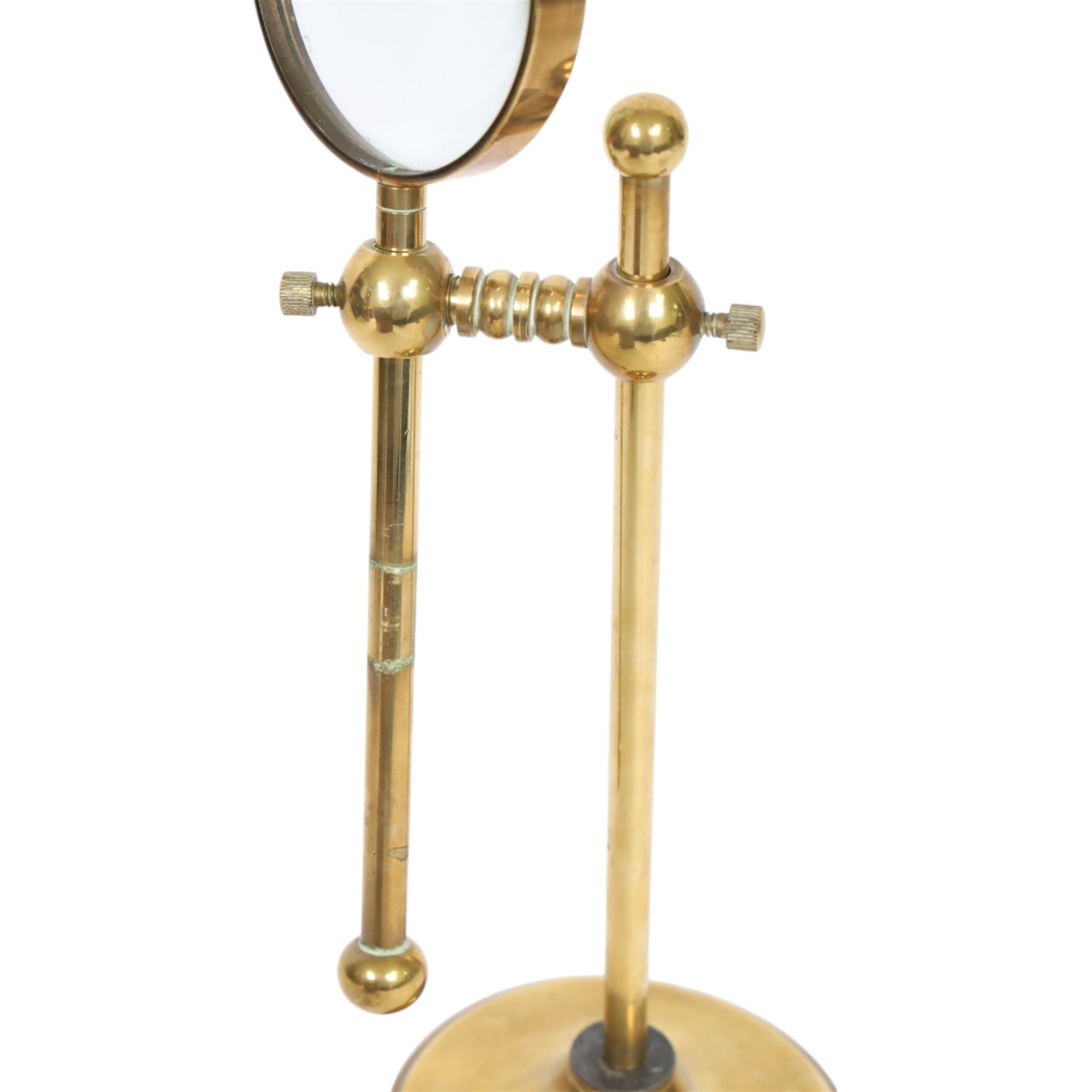 Early 20th century lacquered brass table top adjustable magnifying glass, with pivoting lens upon a circular weighted base, H26cm