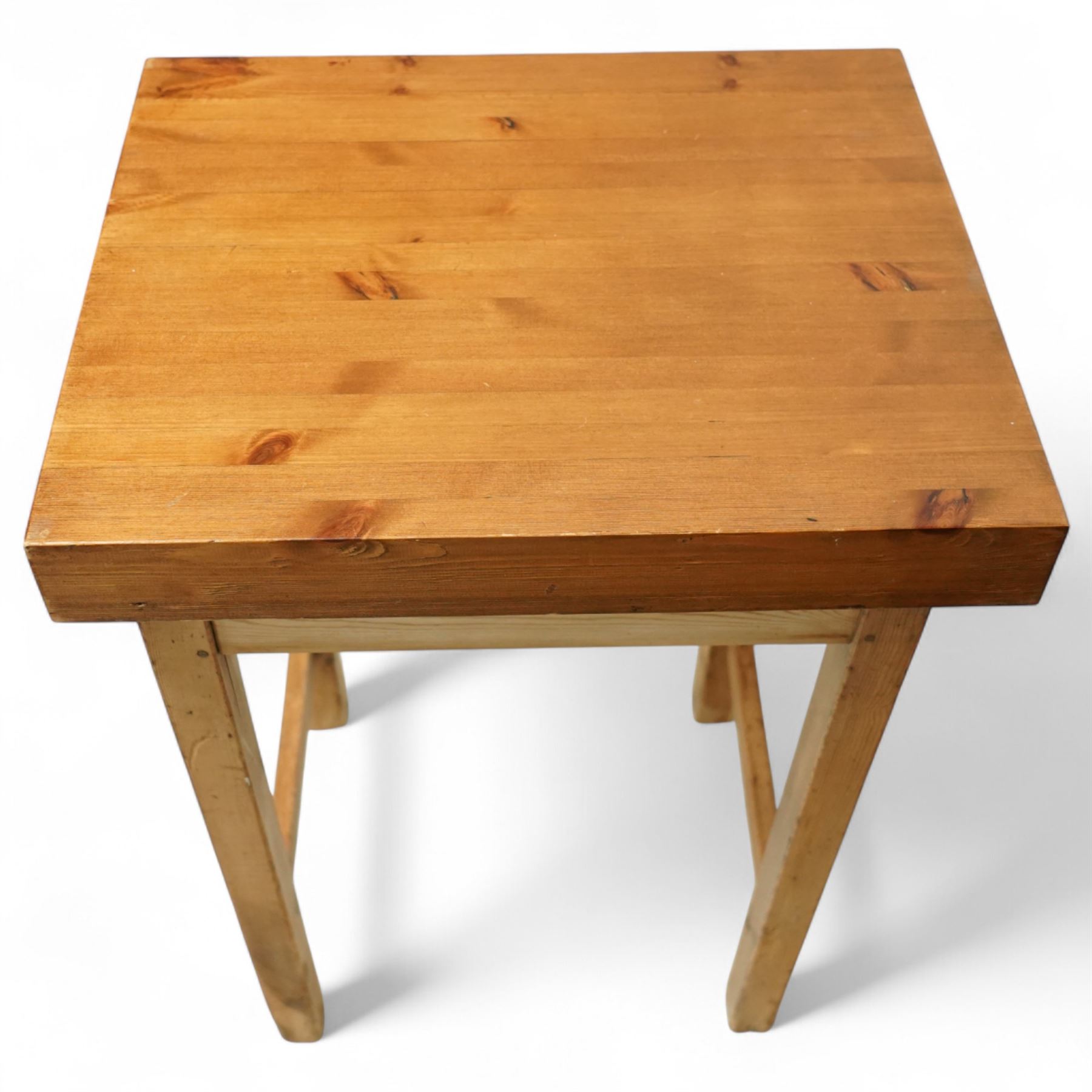 Mid-20th century pine butcher’s block, the thick laminated rectangular top raised on square supports united by side stretchers
