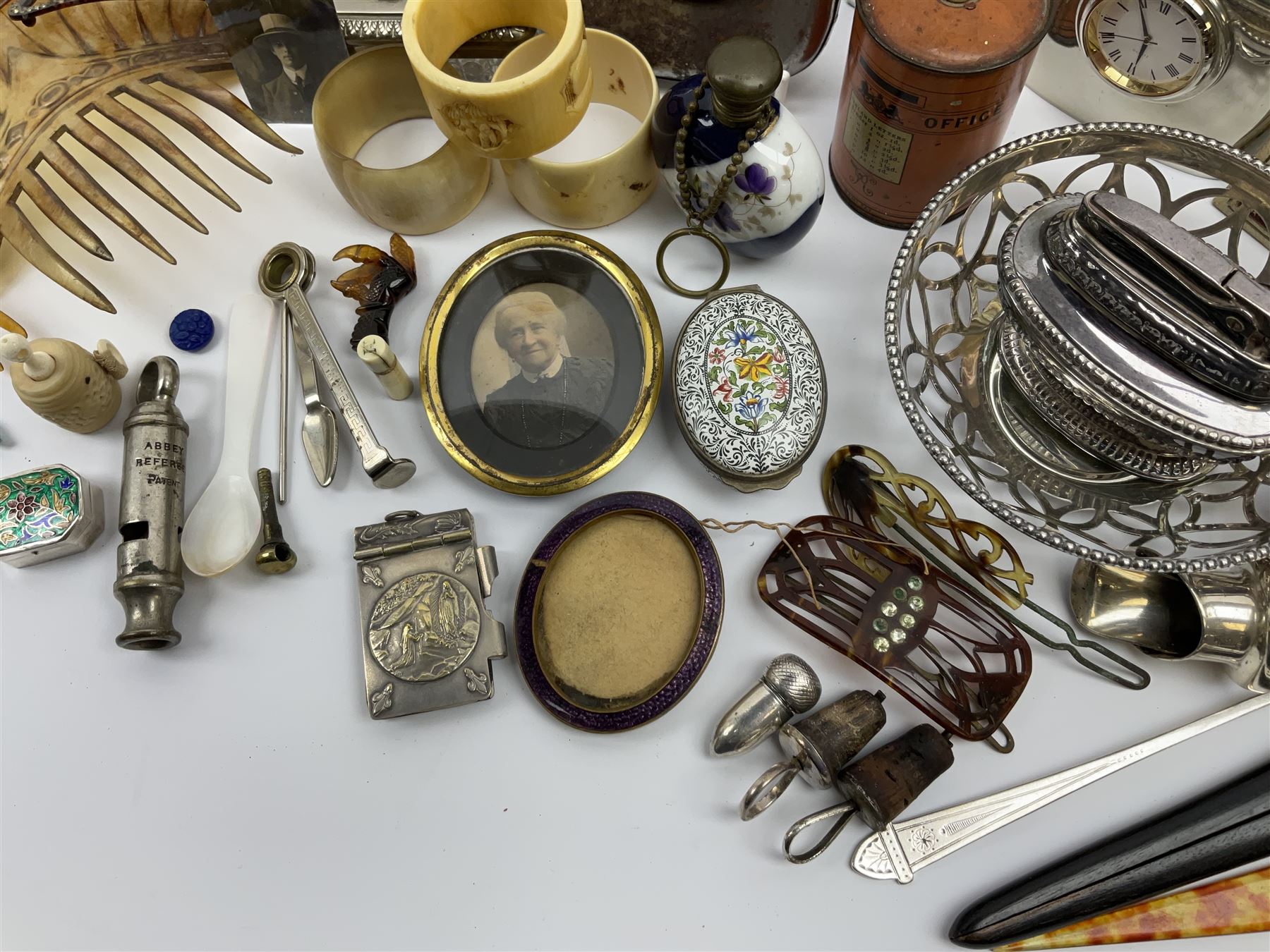 A group of assorted collectables, to include small oval purple guilloche enamel frame, WWII matchbox holder depicting Winston Churchill, Halcyon Days enamel box, Ronson table lighter, ebonised glove stretchers, ivory napkin ring, mother of pearl handled button hook, engine turned cigarette case, etc. 