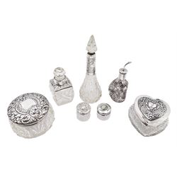 Two silver mounted dressing table jars, one in the form of a heart, both with embossed silver covers and cut glass bodies, hallmarked, together with two smaller examples, one set with mother of pearl, three silver mounted glass scent bottles, including an example with prunus blossom decoration, stamped Sterling, tallest bottle H17cm