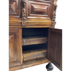Late 17th century Flemish/Dutch rosewood and oak ‘Zeeuwse Kast’ or cupboard, projecting cornice carved with three putti masks, the uprights carved with lion masks over ribbons, flower heads and foliage, enclosed by four geometric panelled doors, lower central upright carved with flower head over foliate ribbon with bird among foliage, the escutcheon hidden by swivel berry carved cover, interior fitted with shelves, two drawers and shallow hinged cupboard, on two large turned and ebonised feet, circa 1680
