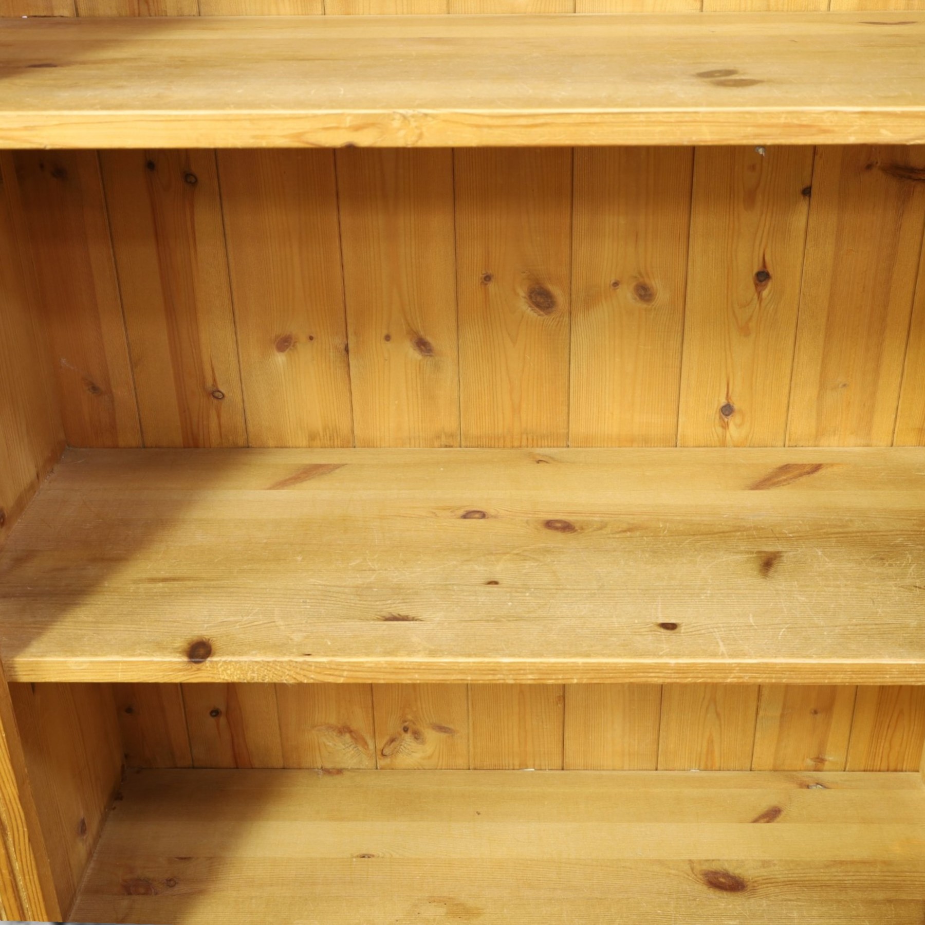 Traditional pine bookcase, projecting cornice with four fixed shelves (H 33cm, D 29cm), fluted sides, raised on a plinth base