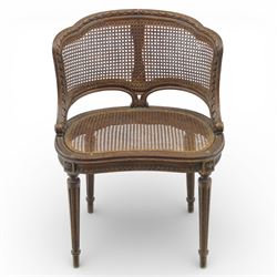 Late 19th century cane bergère armchair, the serpentine shaped back flowing into enclosed arms, the back and seat caned throughout, with carved detail to the crest and arm terminals, on turned legs