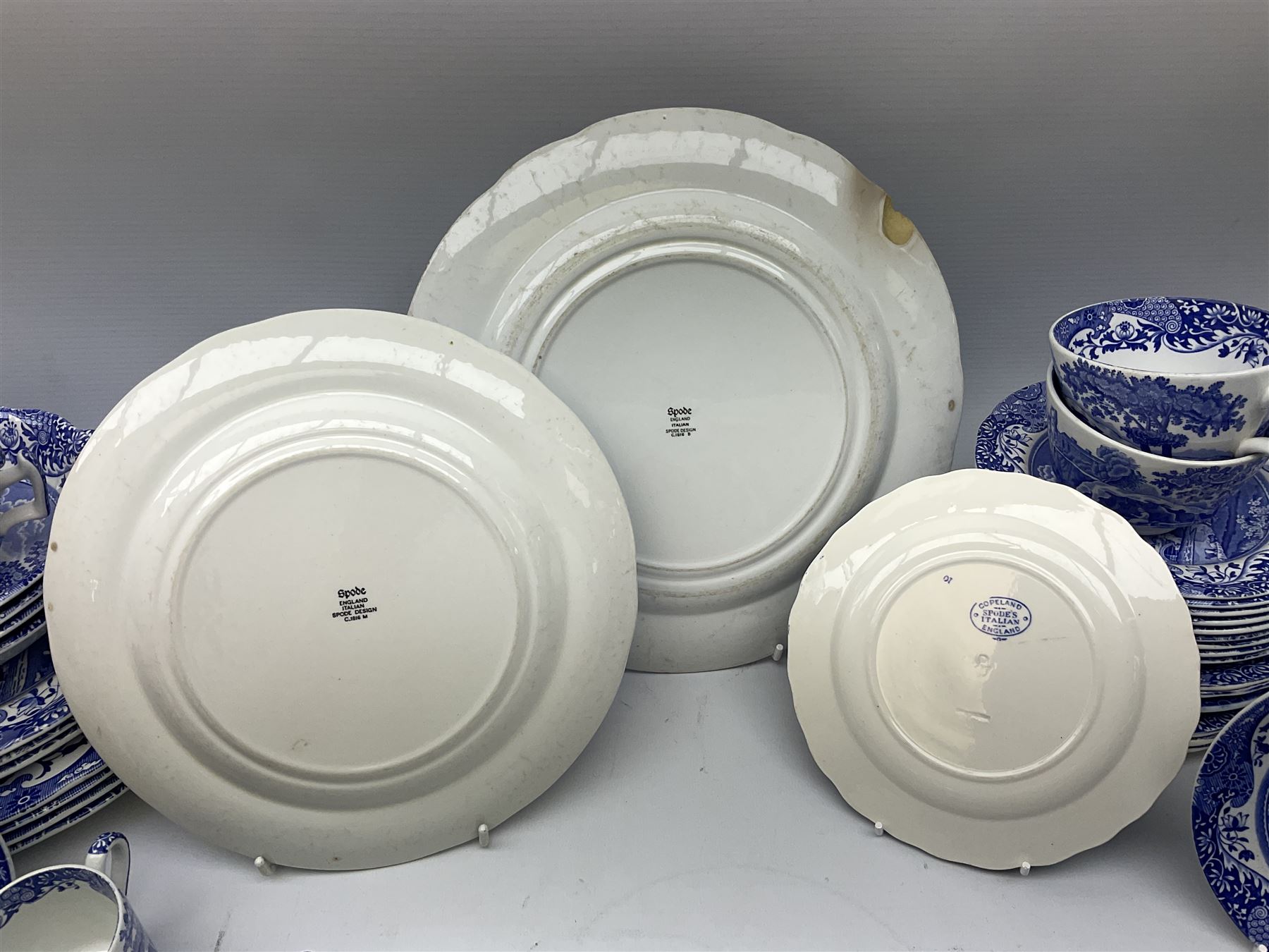 Spode blue and white Italian pattern dinner and tea wares, comprising five dinner plates, four side plates, seventeen side plates, four bowls, ten tea cups and twenty one saucers, five coffee cans and six saucers, and a flan dish, with blue and black printed marks beneath 