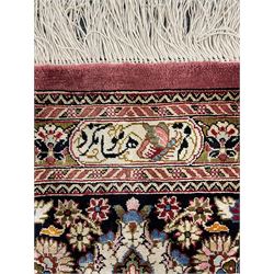 Finely knotted Persian Qom silk rug, overall pink ground with ivory field, the field with central cusped medallion profusely decorated with interlacing foliate and stylised flower heads, multiple band boarder, the main band decorated with a series of stylised motifs and trailing foliage, the outer guard with signature panel 