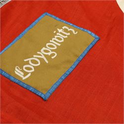 German Third Reich NSDAP flag, with central swastika, blue edged brown panel to the corner with “Łodygowice” embroidered in white, later silver tress added to the edge