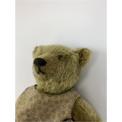 Early 20th century German Steiff teddy bear c1910 with wood wool filled humped back mohair body, swivel jointed head with black boot button eyes and horizontally stitched black nose and mouth, FF metal button to left ear, jointed elongated limbs with felt paw pads and black stitched claws H13