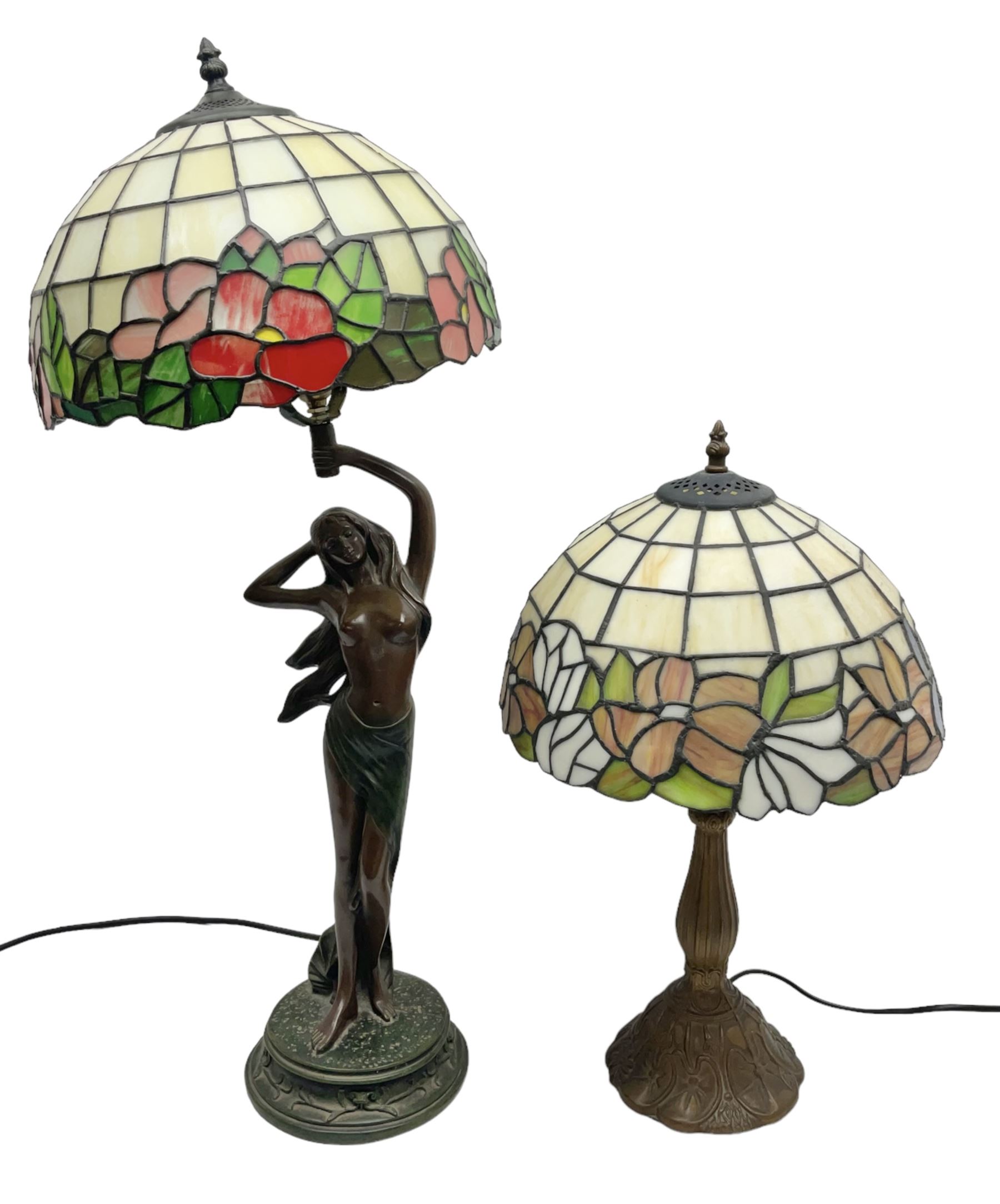 Tiffany style lamp in the form of a semi nude woman holding up a leaded lampshade together with a similar table lamp