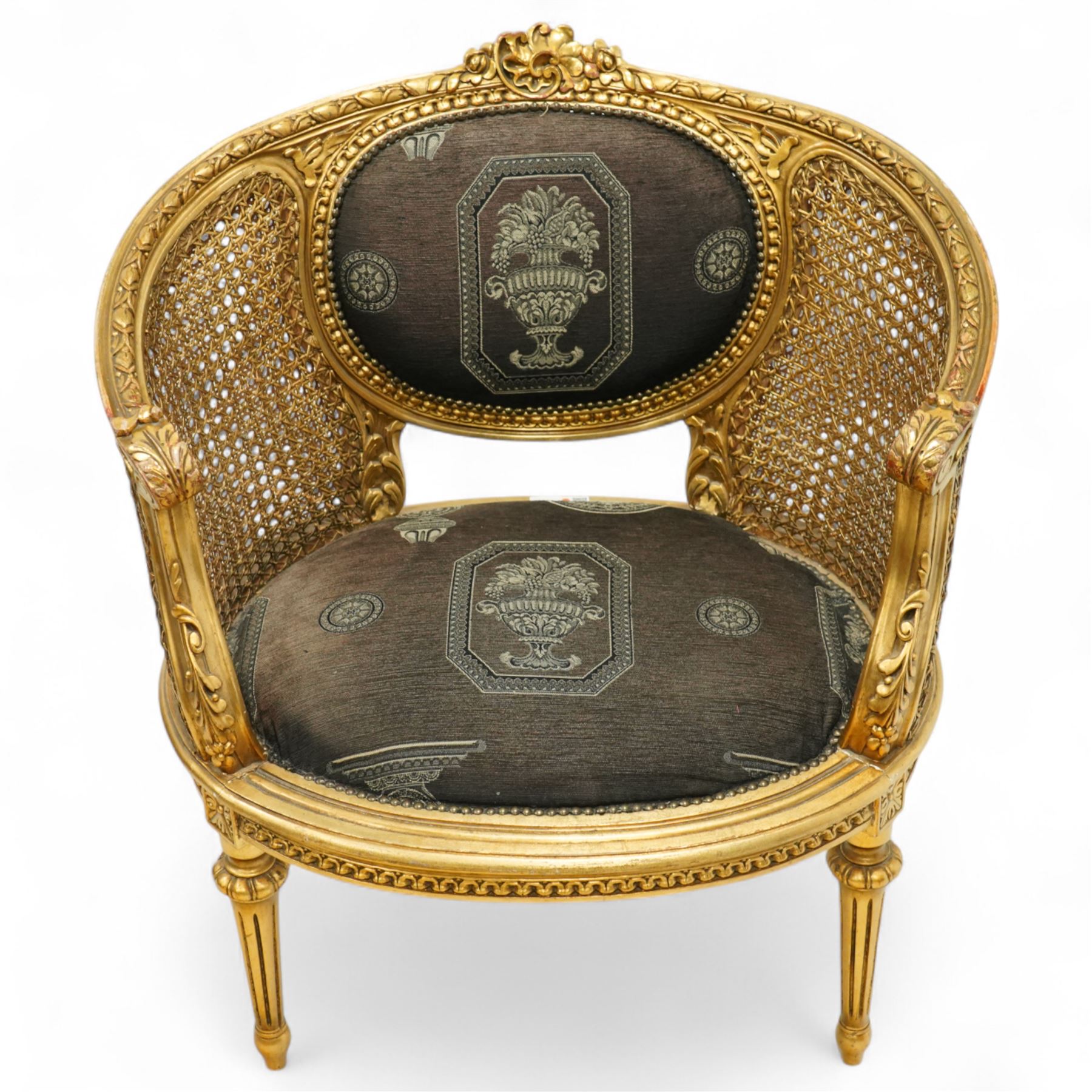 Louis XVI design tub armchair, studded upholstered padded back and seat with double cane side panels on fluted legs 