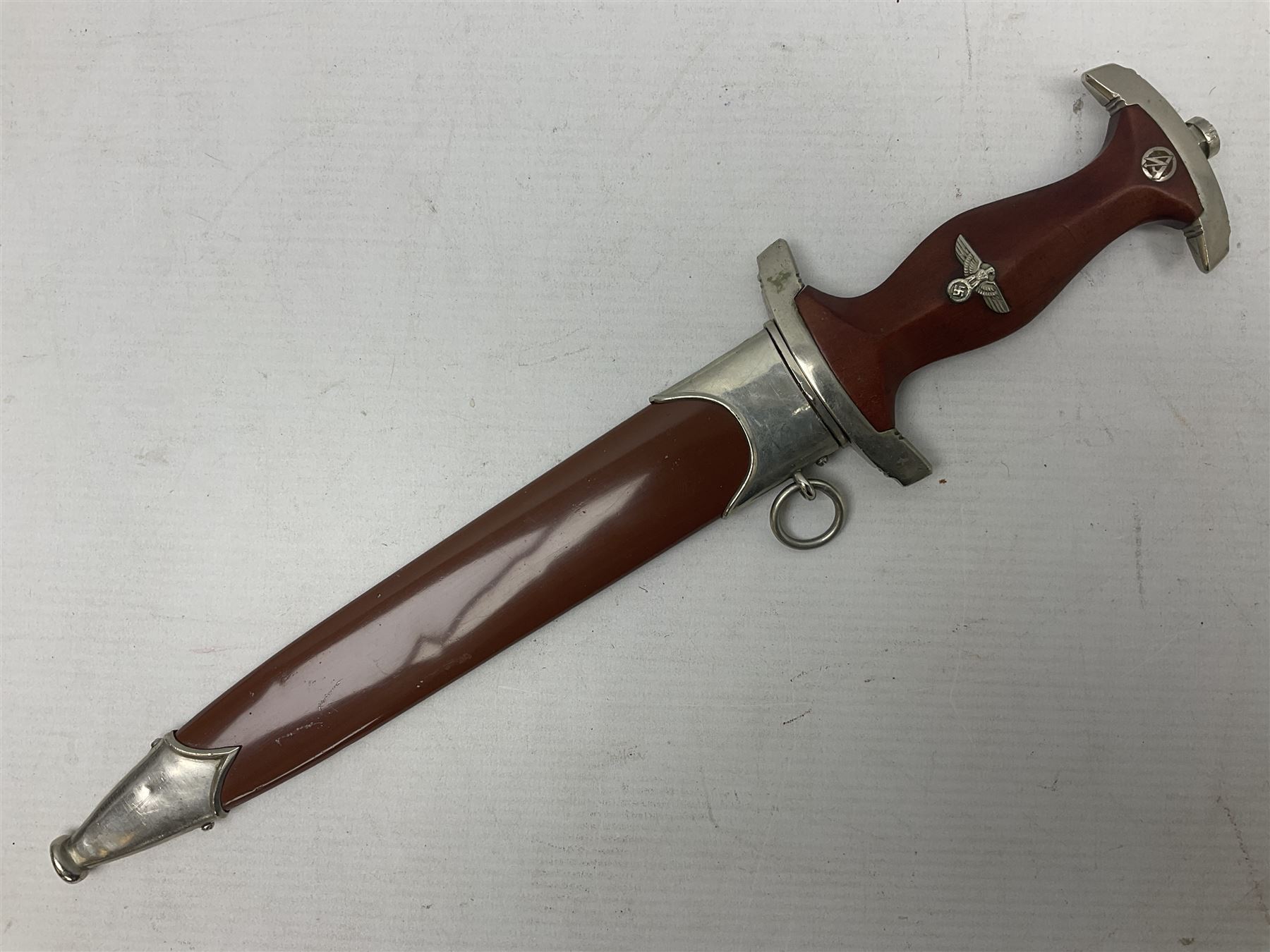 WW2 German SA dagger the 22cm double edged steel blade by G. Felix Gloriawerk Solingen inscribed 'Alles Fur Deutschland', the cross-piece impressed with the SA Gruppen mark Nm verso for Nordmark, wooden grip inset with eagle and SA emblem; in brown painted scabbard with nickel mounts L37cm overall
