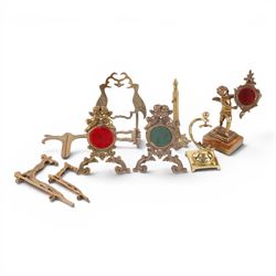 Collection of brass watch stands, including an example modelled as a cherub upon an onyx b...