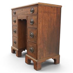 Early 20th century Georgian design figured walnut kneehole desk, rectangular moulded top over one long frieze drawer, kneehole recess with cupboard and drawer above, flanked by six short drawers with oval pressed brass handle plates, moulded plinth base on bracket feet