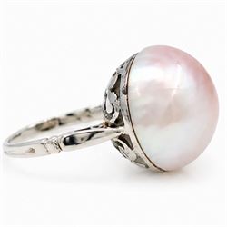 Early 20th century 18ct white gold pink mabe pearl ring, with pierced design floral and scroll gallery