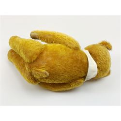 Schuco 'yes-no' teddy bear c1925 with wood wool filled short golden mohair body, linen pads with stitched claws and  tail-operated moving head with glass eyes and vertically stitched nose and mouth H18