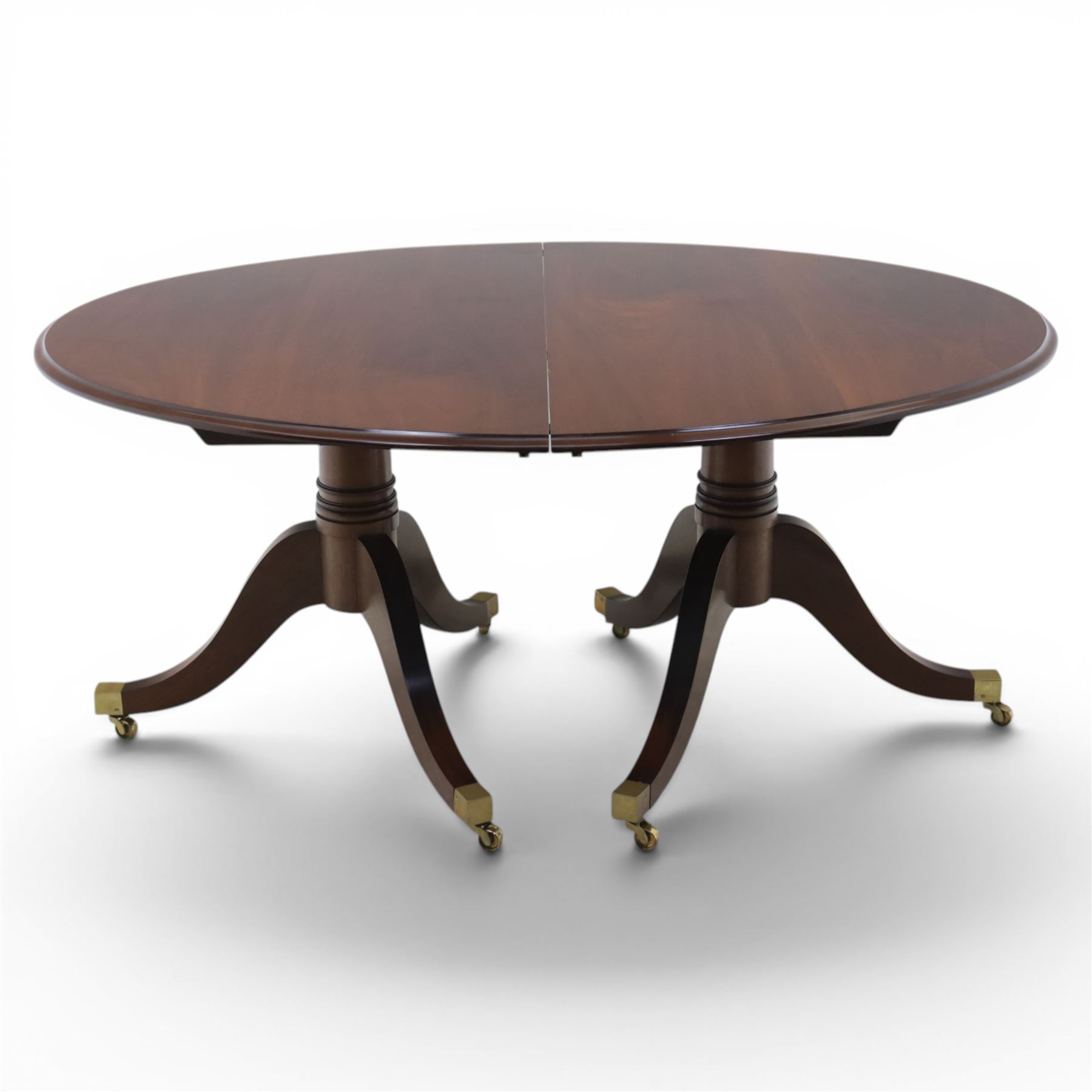 Gott's Pickering - Quality Georgian design rosewood twin pillar extending dining table, with additional leaf, oval form raised on turned columns with tripod legs on cast brass sockets and castors, complete with brass coupling forks, length 164cm without leaf