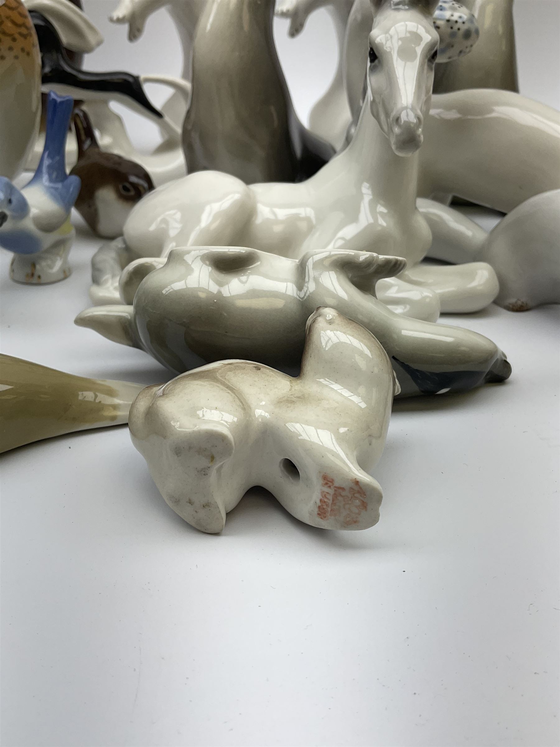 A collection of Russian animal figures, largely comprising Lomonosov examples, to include examples modelled as otters, seals, polar bears, horse, various birds, wolf, hedgehog, etc. 