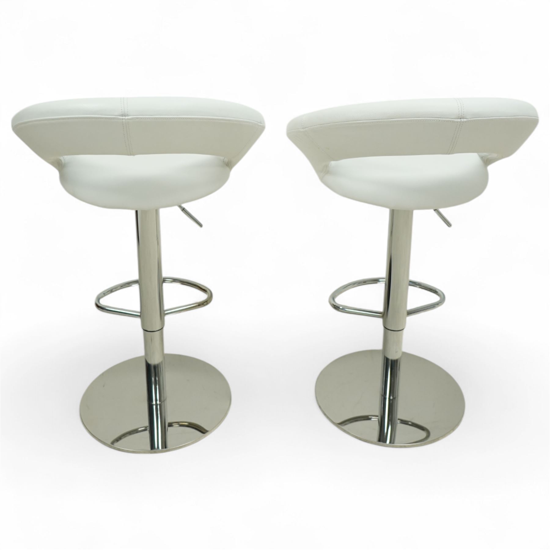 Sorento - Contemporary white leather bar stools, each with a circular padded seat and curved open backrest, on a height adjustable chrome pedestal support with footrest and circular base