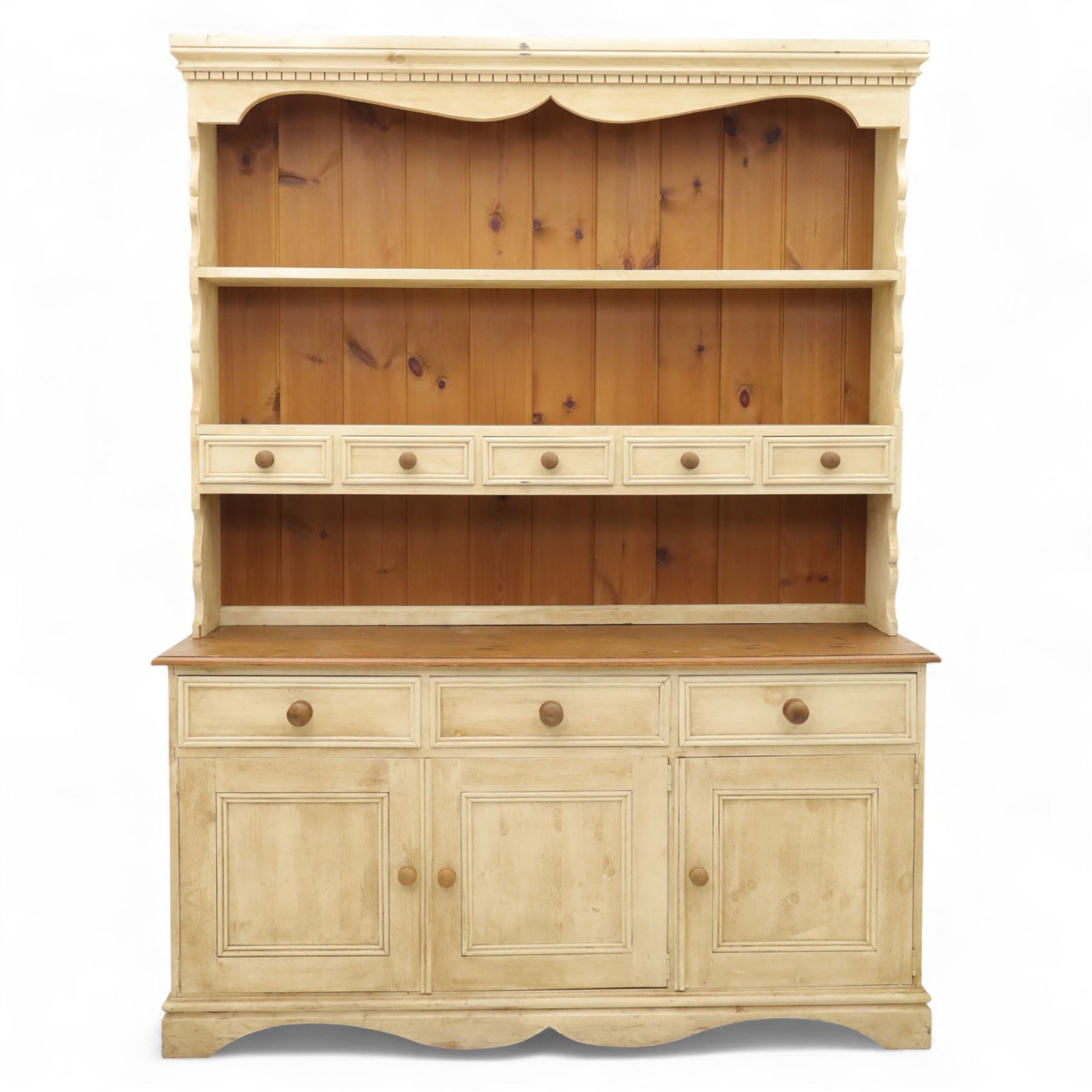 20th century painted pine dresser, moulded cornice above shaped frieze and two open plate shelves, central row of five small drawers with wooden knobs, base fitted with three drawers over a pair of panelled cupboard doors, on shaped plinth base