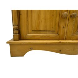 Early 20th century pine kitchen dresser, featuring a hutch with arched top over three open shelves, the base with five drawers over three cupboard doors, turned column supports flanking the doors, scalloped apron base with bracket feet