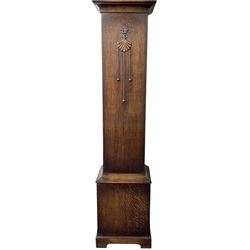 English-1930’s 8-day oak cased grandmother clock, with a break arch hood and trunk with applied carving, brass dial with silvered chapter ring and matted dial centre, three train Westminster chiming movement chiming the quarters and hours on12 gong rods. With pendulum.