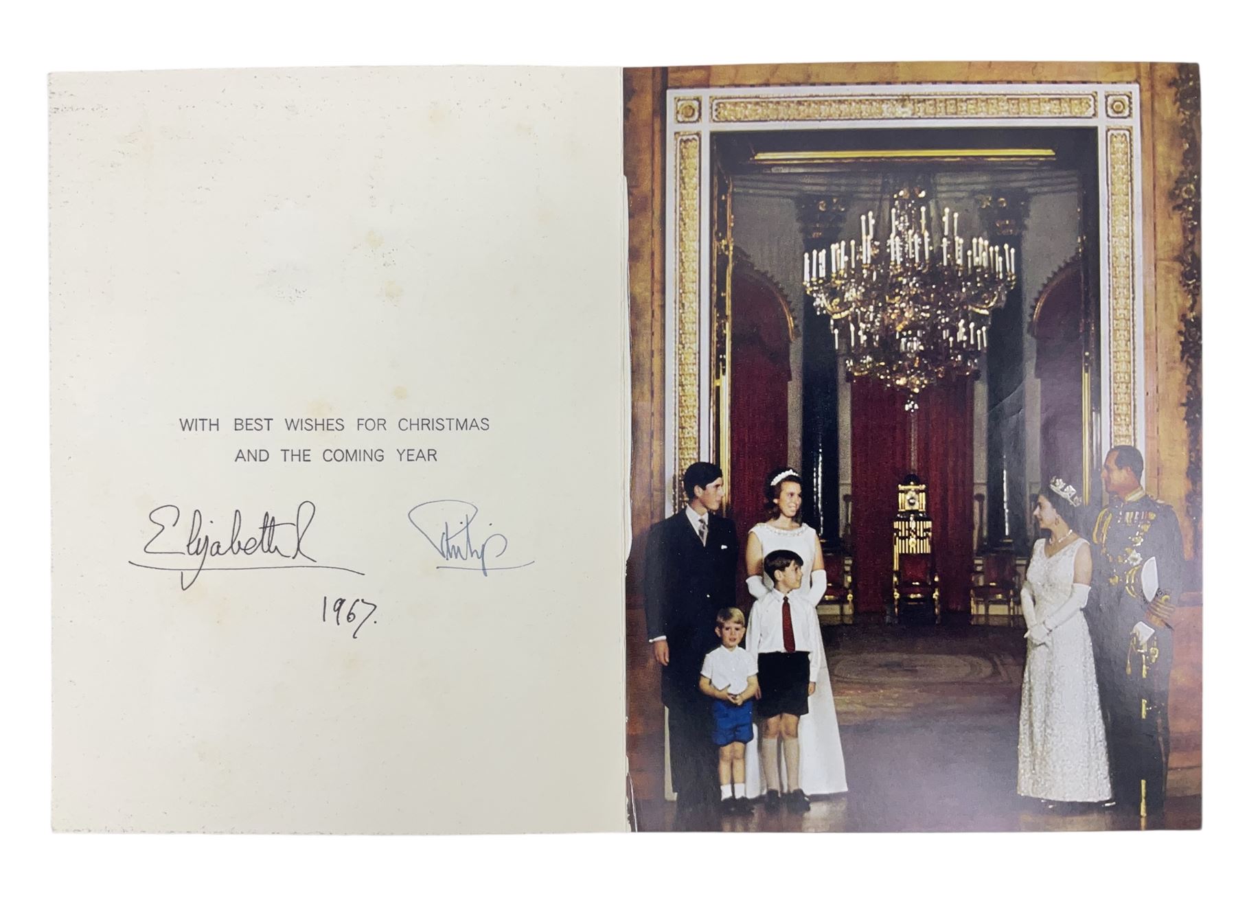 HM Queen Elizabeth II and HRH the Duke of Edinburgh, 1967 Christmas card with two gilt cyphers to front, tipped-in colour print of the Royal Family standing under an archway in Buckingham Palace, signed Elizabeth R and Philip with manuscript date 1967 below