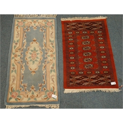  Bokhara red ground rug, geometric medallions (78cm x 120cm), and an oriental style blue ground rug (76cm x 145cm)  