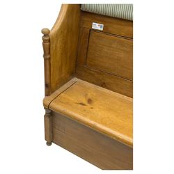 Early 20th century waxed pine pew, inset upholstered striped back panel with hinged box seat enclosing storage, shaped arms and turned supports